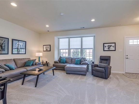 Opposite view of Living Room area with box window case and neutral carpet.