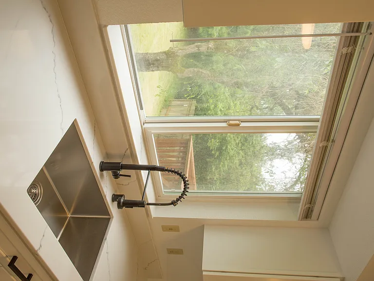 Modern kitchen with large window views, updated fixtures, and plenty of natural light. Bright and functional space for everyday living.