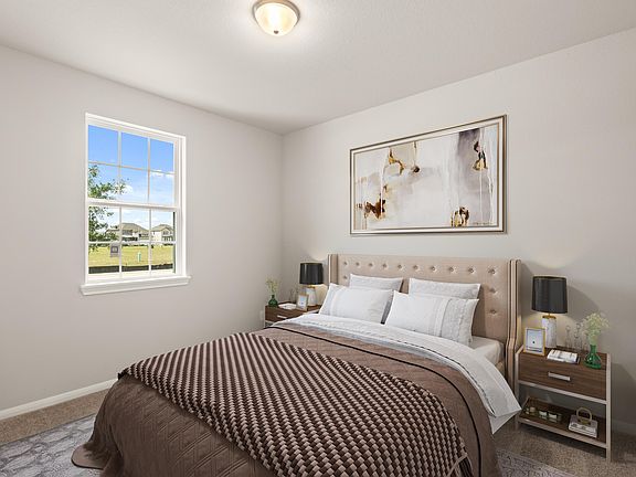 The secondary bedroom features plush carpet, neutral paint, high ceilings and a large window.