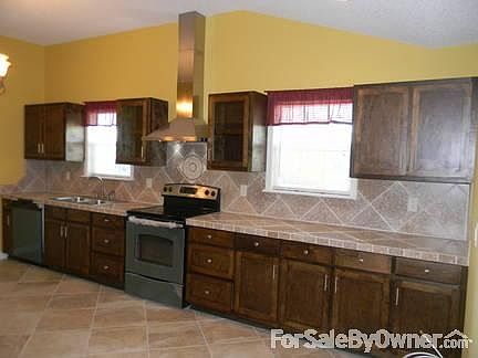 stainless steel & natural stone counters
						:
						SS stove, hood, D/W. 2 Kit windows. Mosaic accent, Chandelier in vaulted ceiling