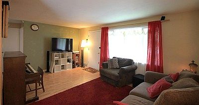 Living Room has vinyl flooring made to look like hardwood and a large picture window for natural lig