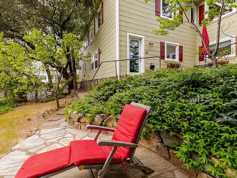 The studio is next to the corner of the house and includes the 2 windows on either side of the door.