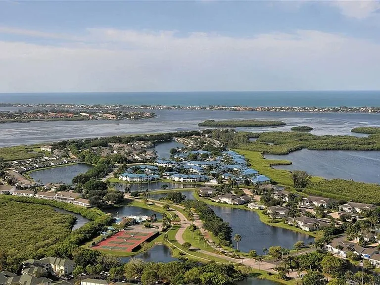 This aerial view of the private, 24 hour gated, guarded island the condo is in the blue roofs. By expanding the picture, the lighted tennis court can be seen next to the Clubhouse, the almost Olympic sized heated pool and the walkouts from the Clubhouse.