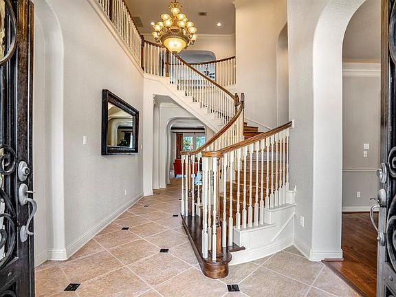 A stylish entry from open artistically designed wrought iron scroll double iron doors entice you to enter this meticulous home, with diagonally laid tile with contrasting insert.