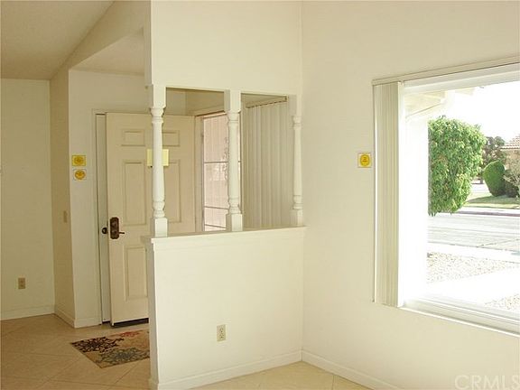 FRONT ENTRY TO LIVING ROOM & ADJOINING DINING ROOM. TILED FLOORING THROUGH OUT HOME.BEAUTIFUL PICTUR