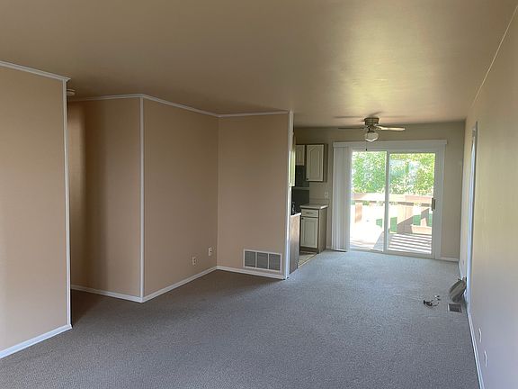 Entry through front door into living room, looking towards dining room and patio door.