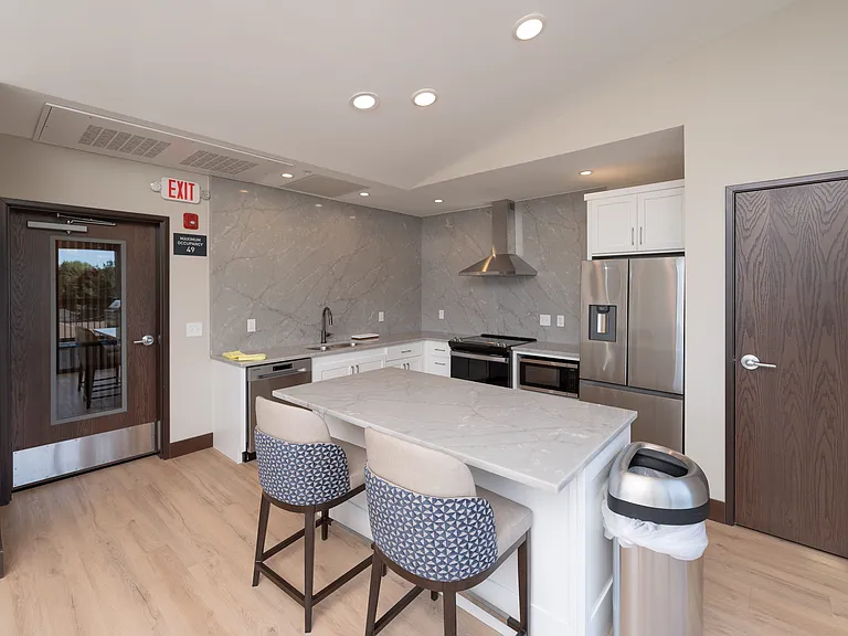 A shared community kitchen conveniently located near the rooftop BBQ and firepit area.