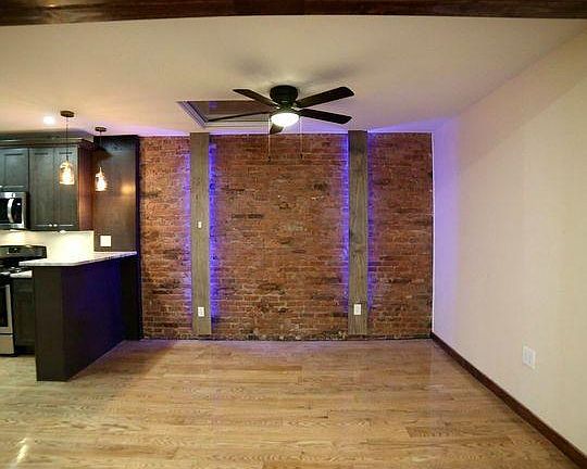 Rustic living room with 100 year old refurbished exposed brick wall and skylight.