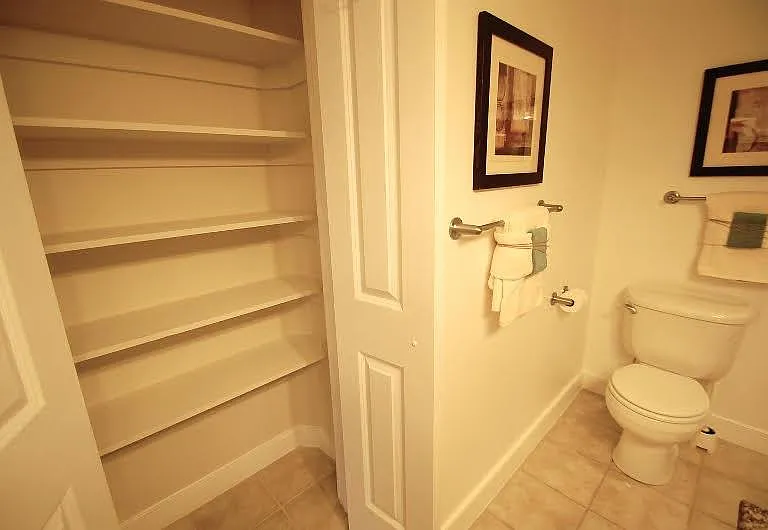 Bathroom with built-in linen closet providing additional storage space.