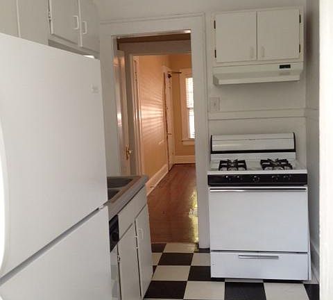 Kitchen leads to small hall before you reach the main living space