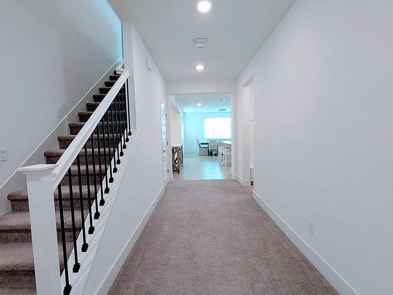 Stunning architectural detail defines this grand hallway and staircase. The open, airy design creates a warm and inviting atmosphere, seamlessly connecting the living spaces throughout this beautiful home.