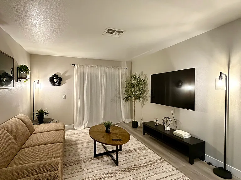 Additional view of the thoughtfully designed living area highlighting a large mounted TV and the open-concept layout and warm, welcoming atmosphere.
