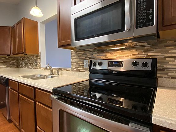 Stainless steel appliances, solid surface counters and tile accents around all counters.
