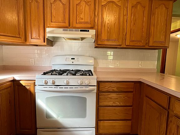 Kitchen has many cabinets and gas stove.