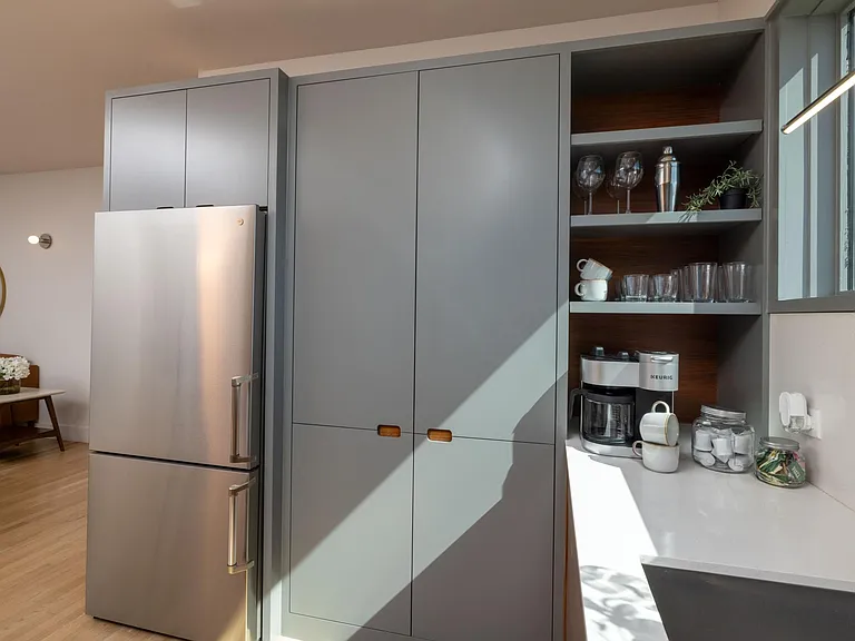Compact kitchen fully stocked with all essentials and sleek stainless steel appliances_everything you need in a cozy space.