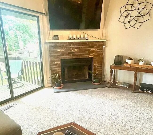 3rd View: Sunken living room with fireplace and sliding glass doors leading to a private deck.