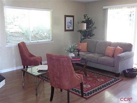 Living room with sliders to the covered patio and fenced back yard.  Laminate wood floors throughout.