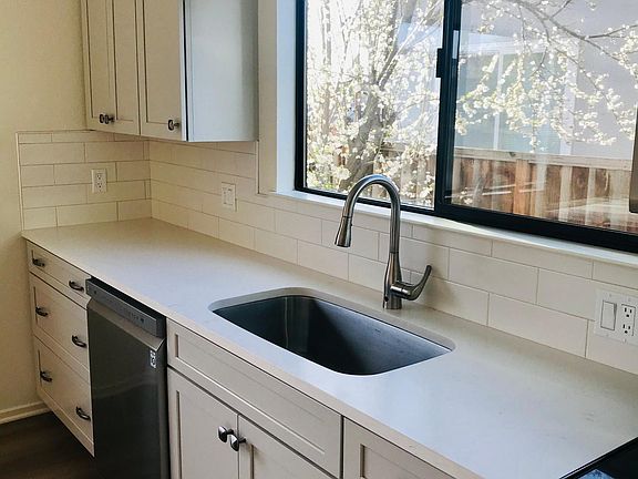 Large stainless sink Quartz countertops Subway tile splash
