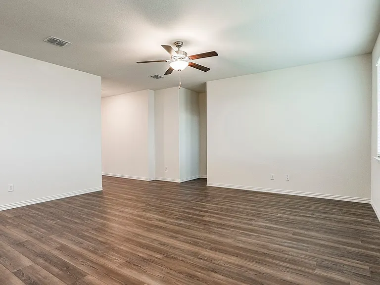 Empty room featuring dark hardwood / wood-style floors and ceiling fan