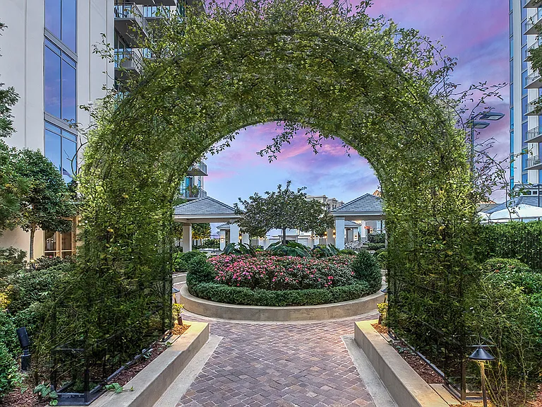A picturesque courtyard entrance wrapped in greenery, creating a graceful pathway to shared outdoor spaces and moments of everyday escape