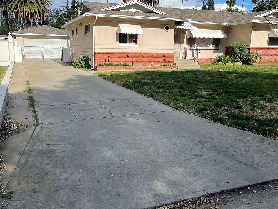Front of House with Long Driveway Leading to Garage.
Gate Secures Entrance into Backyard.