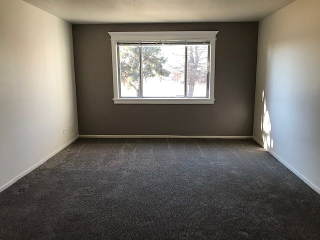 Spacious living room. Front door is on the right. Not visible due to spaciousness of this room. Neither is the hallway entrance to the left. Kitchen entrance behind.