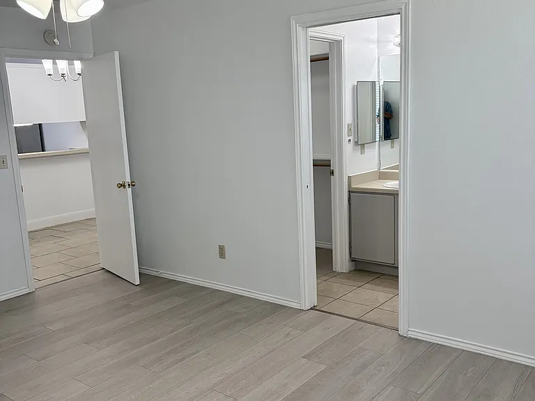 Primary bedroom viewing bathroom to right and dining area to left