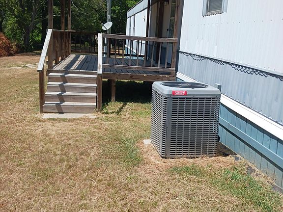 back of home covered back porch and newer central ac unit