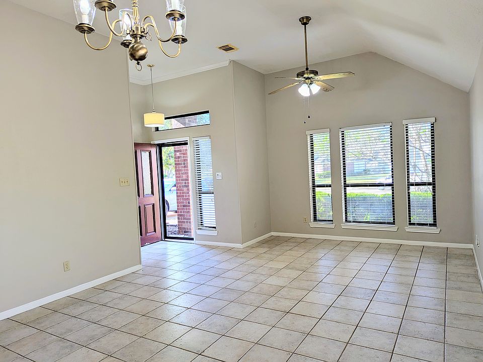 Step inside to a spacious open-concept living room featuring vaulted ceilings, elegant lighting, and large windows that flood the space with natural light.