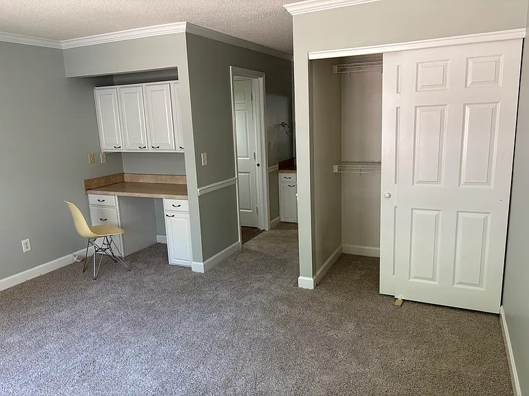 Master bedroom with built-in office area and closet