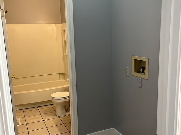 Laundry off hallway that connects to bathroom