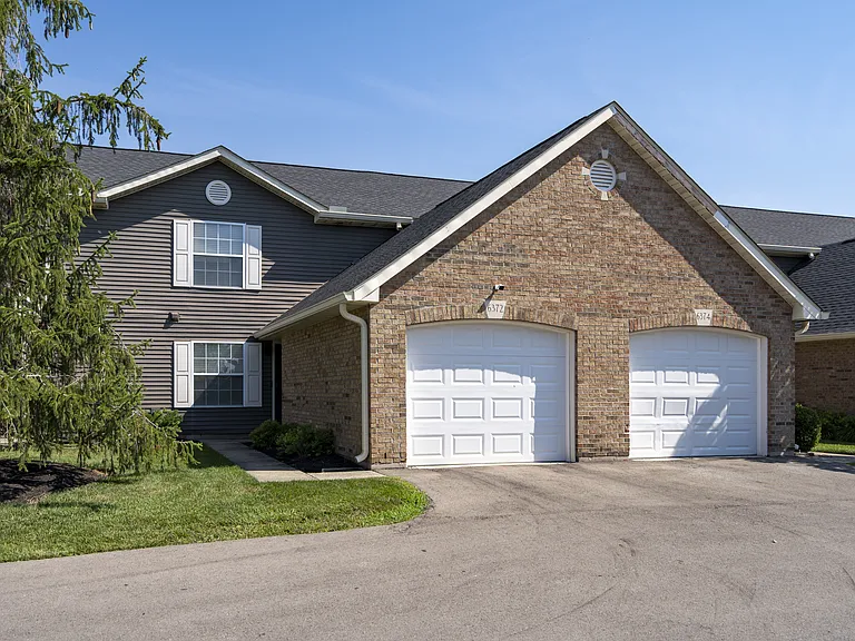 Welcome to a thoughtfully designed home with classic curb appeal, featuring a spacious driveway and inviting architectural details.