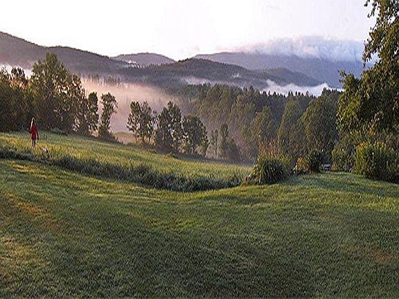 Early morning fog rises off the hills and hay fields