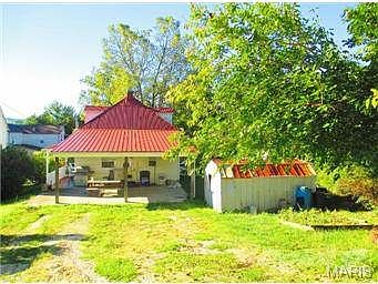 View of back of home, storage building & off street parking.
