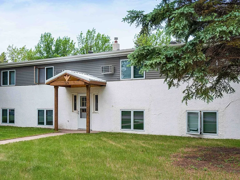 Charming two-story apartment building surrounded by lush greenery, featuring a welcoming entrance and ample natural light. Charming two-story apartment building surrounded by lush greenery, featuring a welcoming entrance and ample natural light.