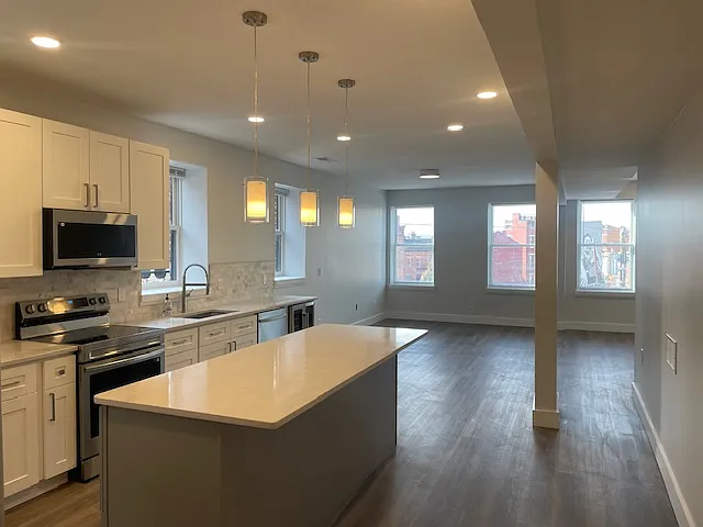 Kitchen opens up to massive dining room / living room space with lots of bright light.