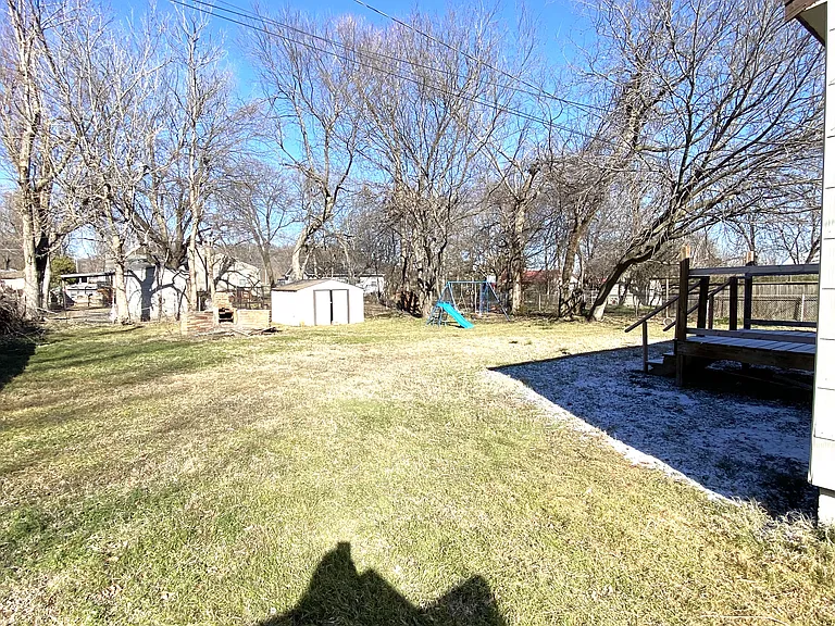 large backyard with shed and play set