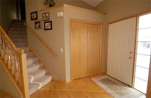 Invite your guests into this warm and welcoming foyer with wood floors, closet space, and stairs to the upper level