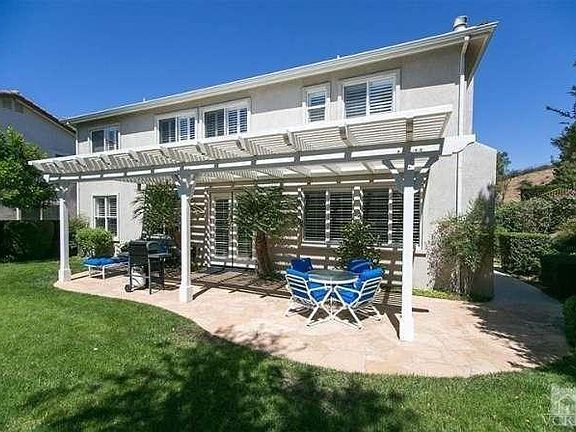 View from the backyard of the house and patio cover.Nice Grass area and Palos Verdes Stone patio.