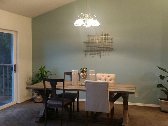 dining room with slider to large balcony, vaulted ceilings and skylights