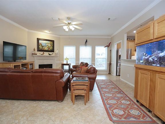 The family room, with crown molding, is very spacious, with a gaslog fireplace on one end, and overlooks the pool area.