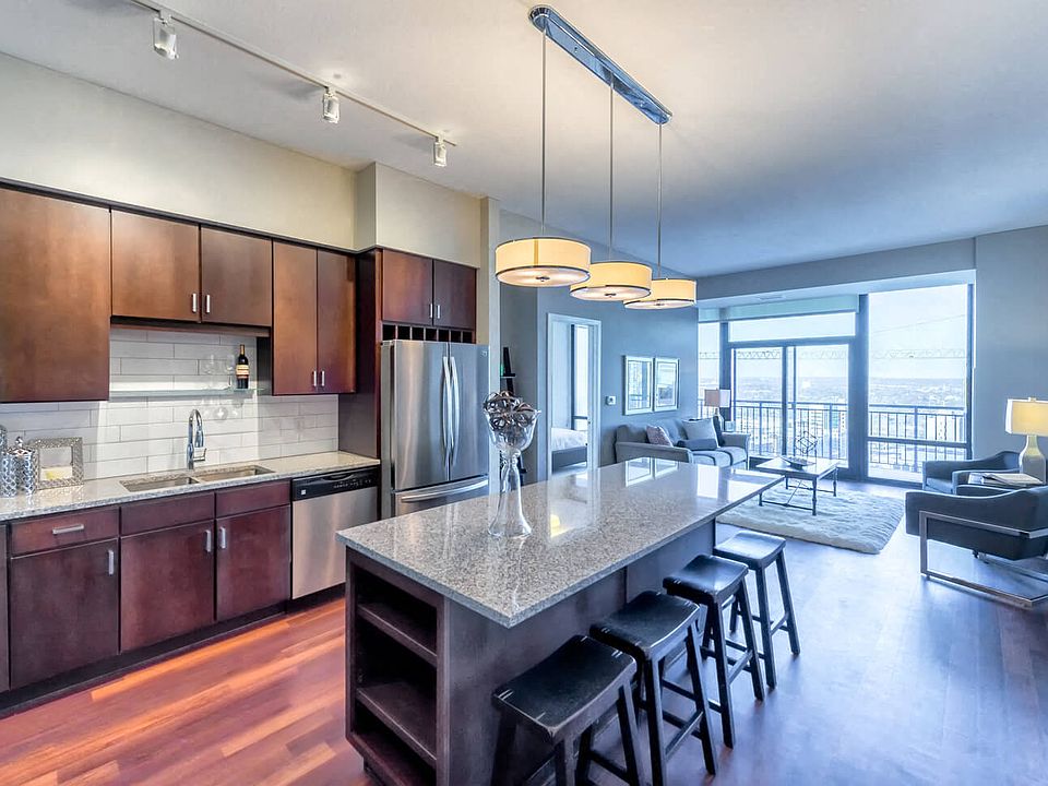 Nic on 5th Apartments in Minneapolis, Minnesota- Large common room with wooden cabinets, floors and granite countertops