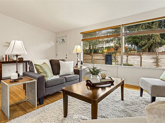 Main floor living room as seen from kitchen, with large picture windows and western exposure. 7714 18th Ave SW, Seattle, WA 98106 - NWMLS# 1870781