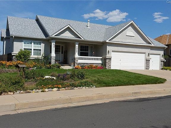 Beautifully landscaped yard with mature trees, flower beds and lots of perennial