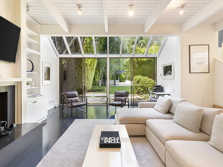 Large floor to ceiling doors that lead to the spacious backyard and BBQ area