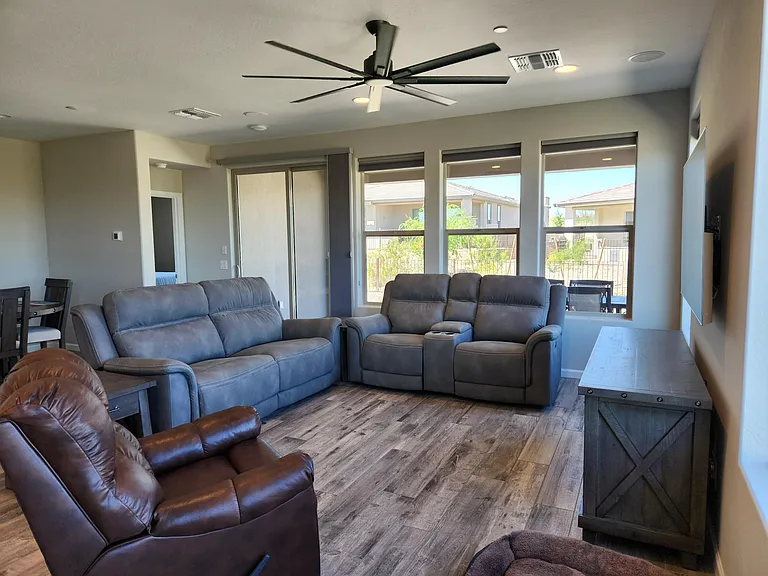 Living room with reclining couches and surround sound system and cooling ceiling fan