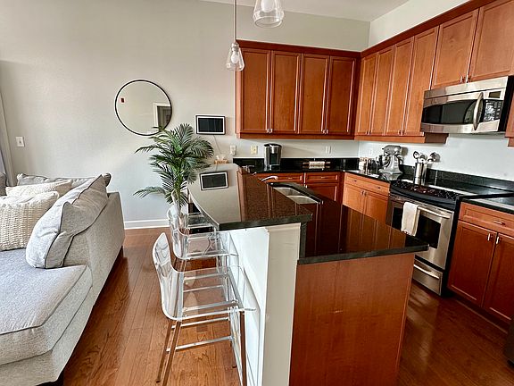 A curved kitchen island includes a raised bar area with space to tuck barstools tucked underneath.