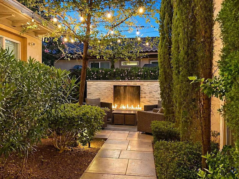 Front house lounge area with gas fireplace, waterfall and string lights