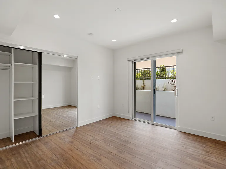 Bedroom with Mirrored Closet and Patio