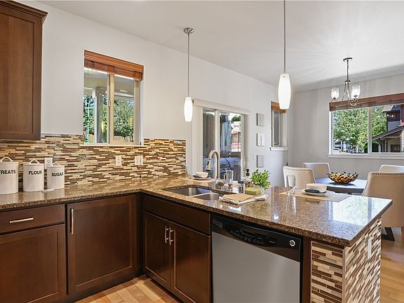 The kitchen features a breakfast bar with pendant lighting! Slab granite counter tops and impressive counter-to-cabinet backsplash are sure to impress!
